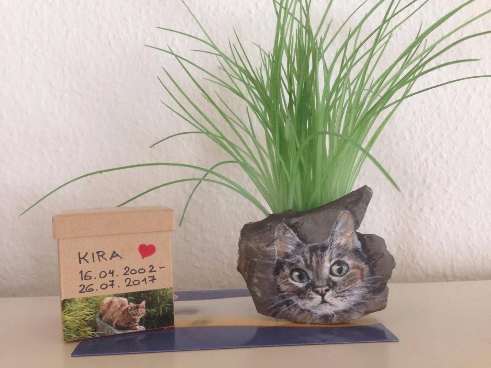Bemalter Gedenkstein mit einem Katzenporträt